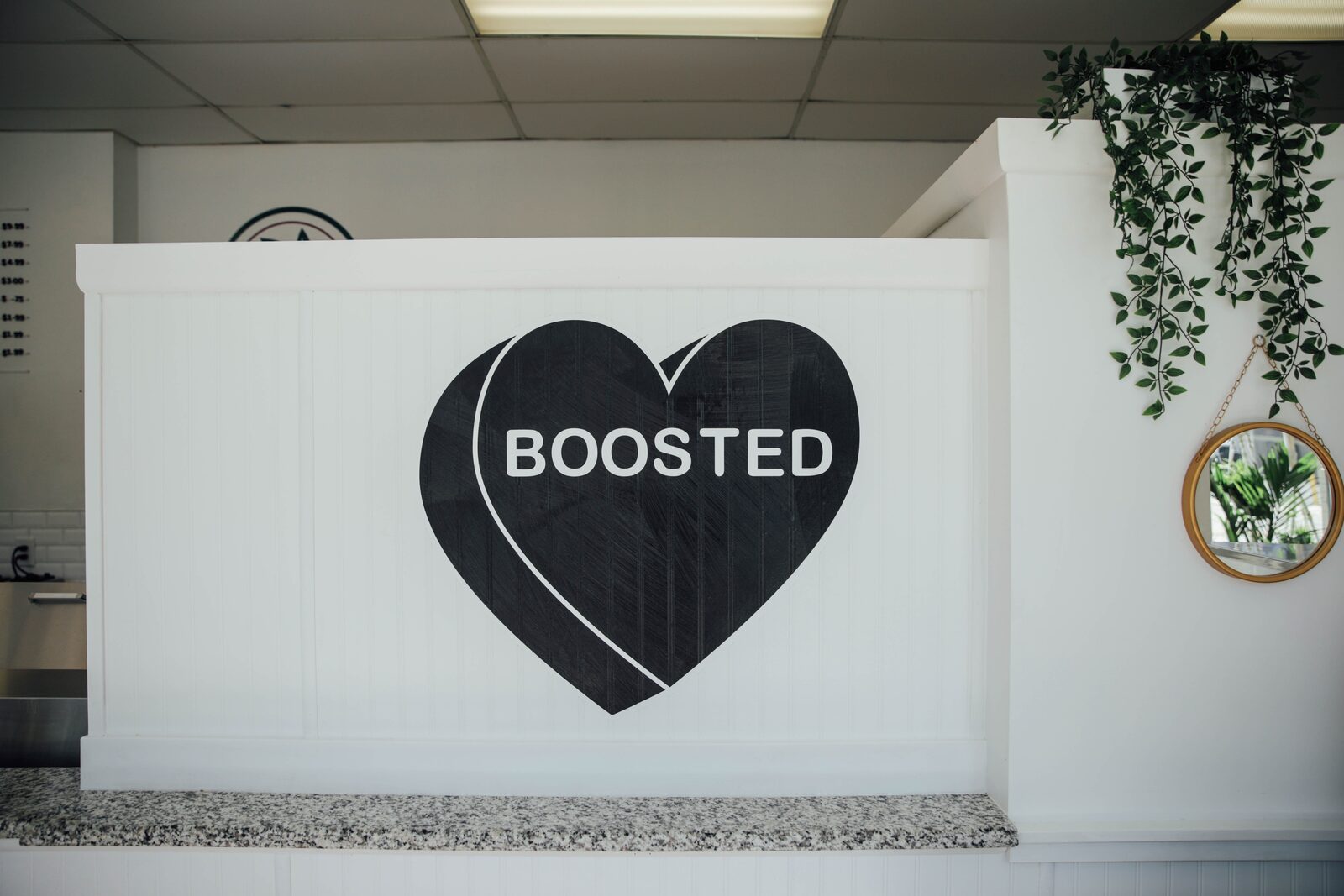 The counter inside the shop with the BOOSTED heart behind it