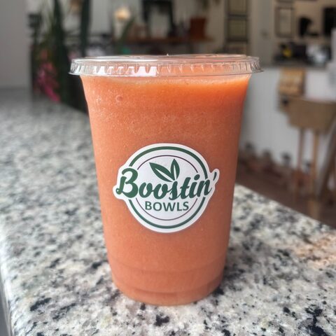 Orange smoothie with orange juice, strawberries, mango, banana, and honey